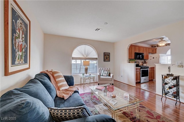 living room featuring ceiling fan and light hardwood / wood-style floors