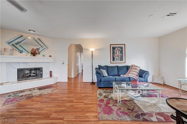 living room with light wood-type flooring and a tile fireplace