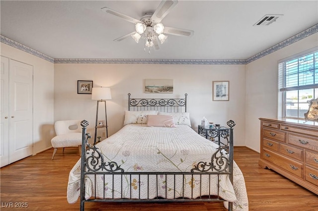 bedroom with ceiling fan, a closet, and light hardwood / wood-style floors