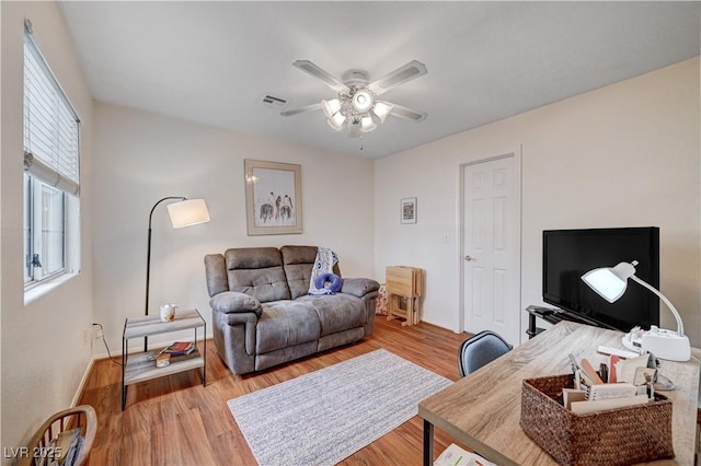 living room featuring ceiling fan and hardwood / wood-style flooring