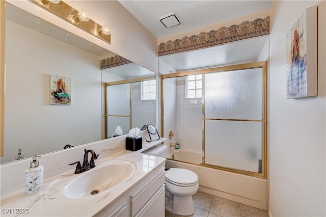 full bathroom featuring shower / bath combination with glass door, vanity, toilet, and tile patterned flooring