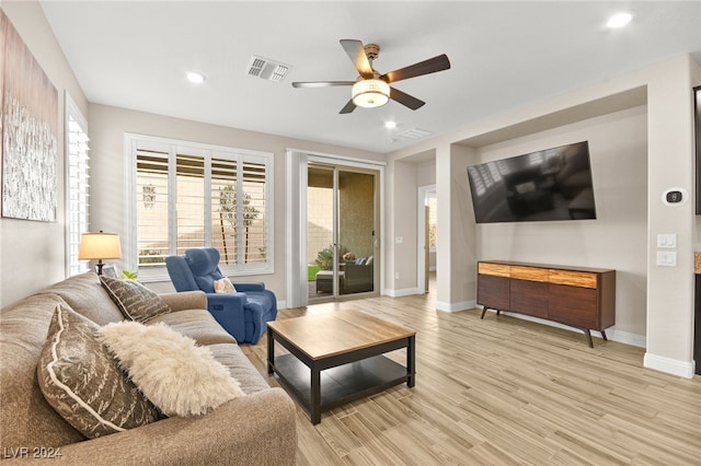 living room with ceiling fan, plenty of natural light, and light wood-type flooring