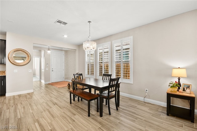 dining area featuring light hardwood / wood-style flooring and an inviting chandelier