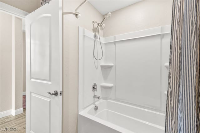 bathroom with wood-type flooring and shower / tub combo with curtain