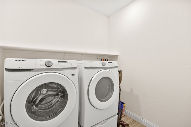 laundry room with hardwood / wood-style floors and washing machine and clothes dryer