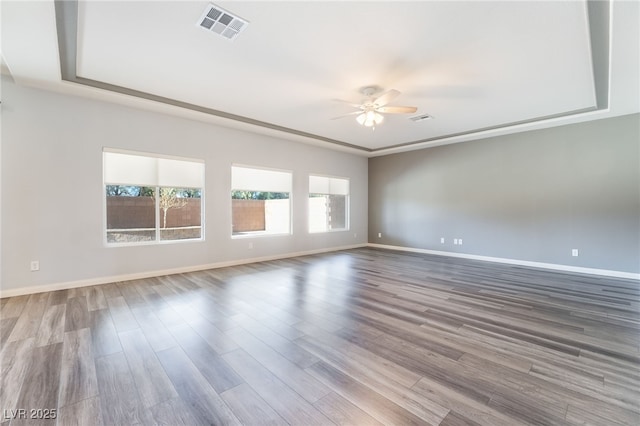 spare room featuring a tray ceiling, ceiling fan, and hardwood / wood-style flooring