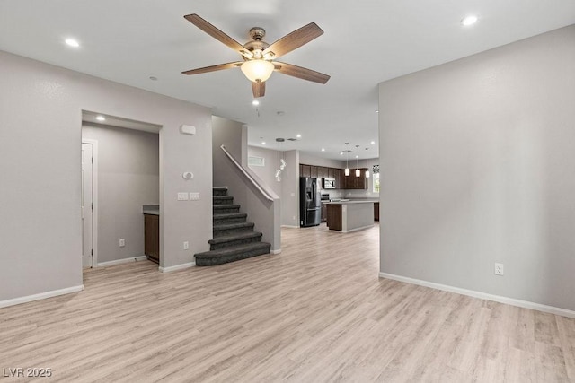 unfurnished living room with ceiling fan and light hardwood / wood-style flooring