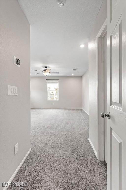 carpeted spare room with ceiling fan