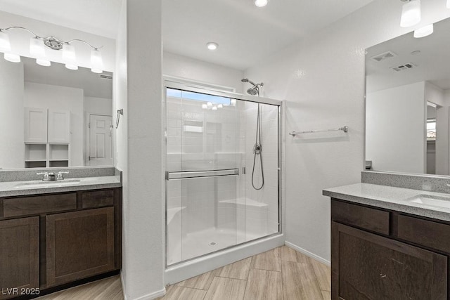 bathroom with vanity, plenty of natural light, and a shower with door