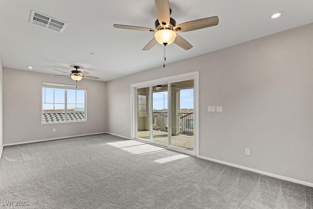 carpeted spare room featuring ceiling fan