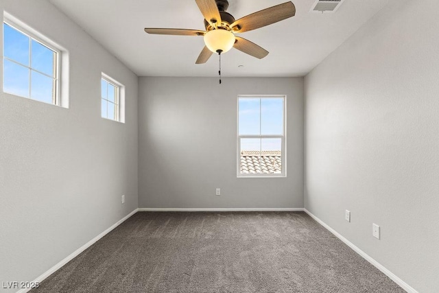 carpeted spare room featuring ceiling fan and a healthy amount of sunlight