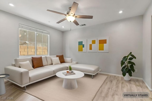 living room with ceiling fan and light hardwood / wood-style floors