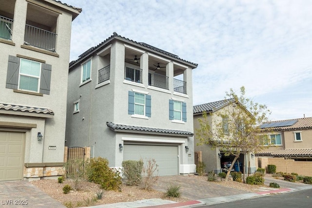 view of front of property with ceiling fan, a balcony, and a garage