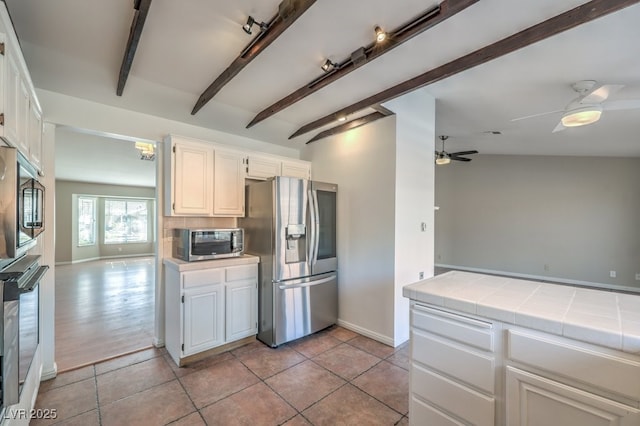 kitchen featuring white cabinets, stainless steel appliances, tile counters, and ceiling fan