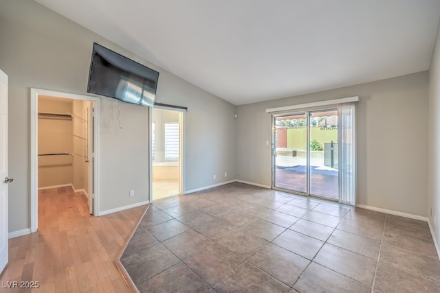 spare room with light hardwood / wood-style flooring and vaulted ceiling