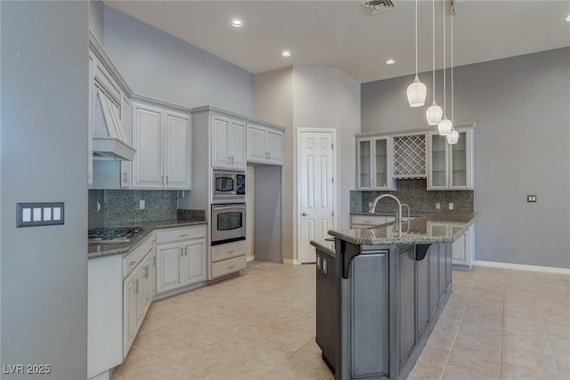 kitchen featuring white cabinets, a breakfast bar, appliances with stainless steel finishes, and dark stone counters