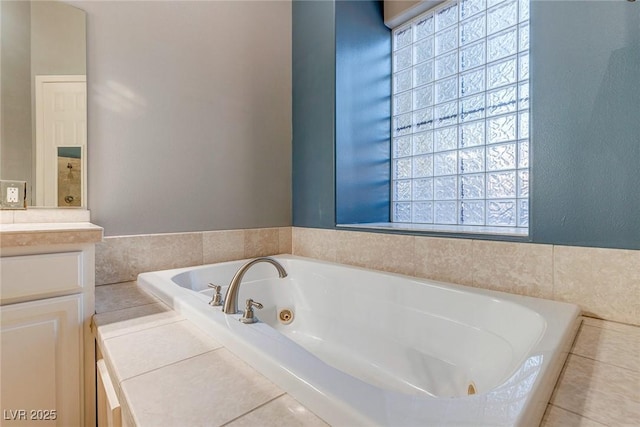 bathroom featuring tiled tub and vanity