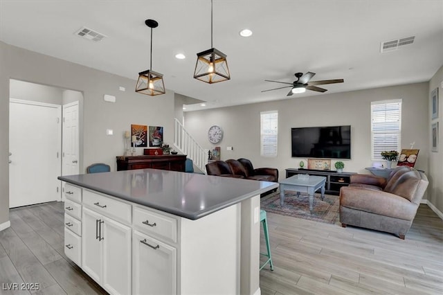 kitchen with white cabinetry, plenty of natural light, a kitchen island, and hanging light fixtures