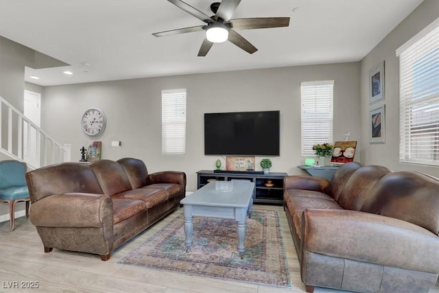 living room featuring ceiling fan and a healthy amount of sunlight