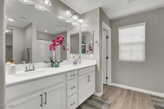 bathroom with a shower, vanity, and wood-type flooring