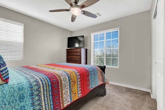 carpeted bedroom with ceiling fan and multiple windows