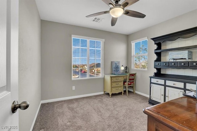 office space featuring ceiling fan, a healthy amount of sunlight, and light carpet