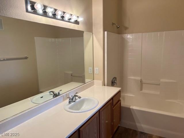 bathroom featuring hardwood / wood-style flooring, vanity, and tub / shower combination