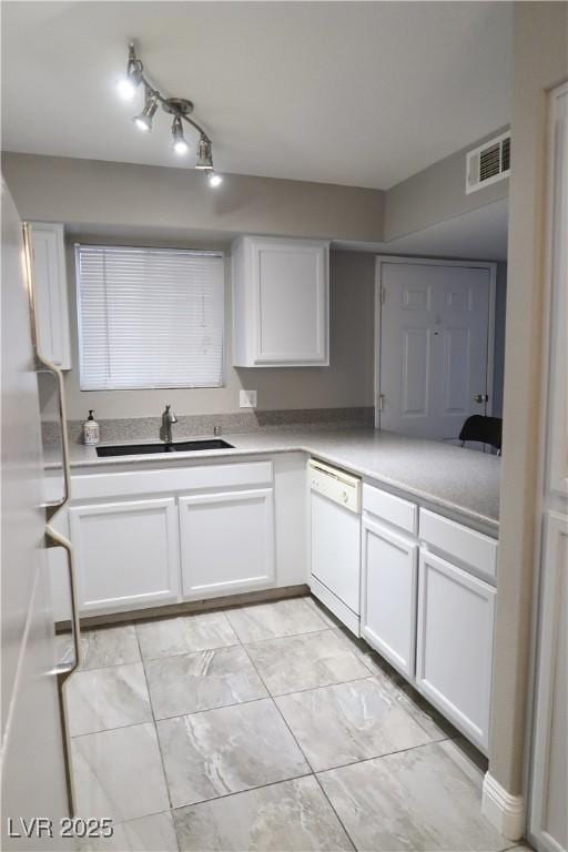 kitchen featuring white cabinetry, dishwasher, and sink