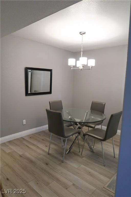 dining room featuring light hardwood / wood-style flooring and a notable chandelier