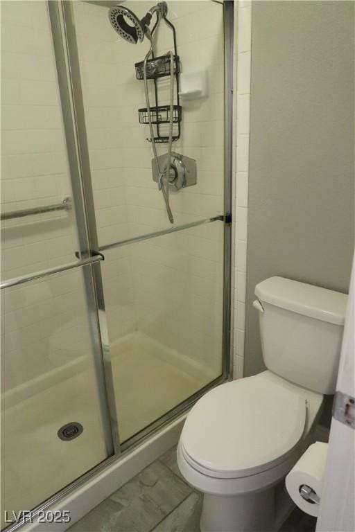 bathroom featuring an enclosed shower and toilet