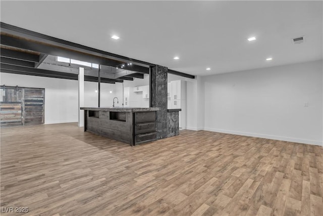 basement featuring light hardwood / wood-style floors and indoor wet bar