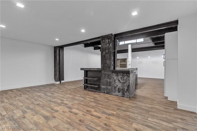 unfurnished living room featuring hardwood / wood-style flooring and sink