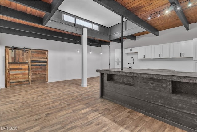 basement with wooden ceiling, sink, rail lighting, and wood-type flooring