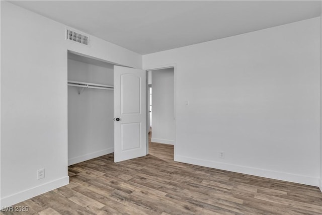 unfurnished bedroom featuring hardwood / wood-style flooring and a closet