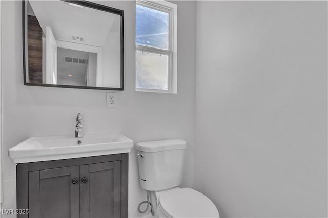 bathroom with plenty of natural light, vanity, and toilet