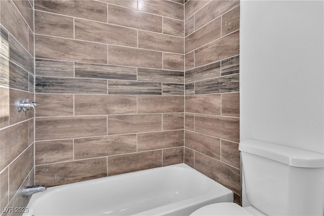 bathroom with tiled shower / bath and toilet