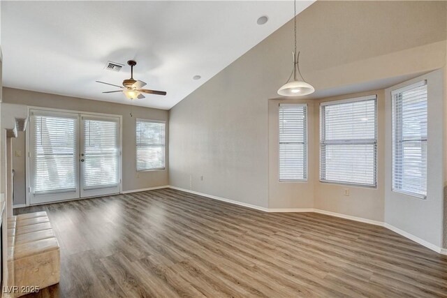 unfurnished room with ceiling fan, lofted ceiling, and wood-type flooring