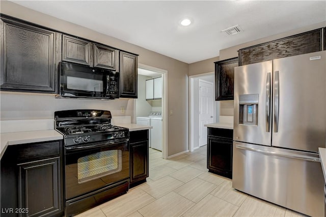 kitchen with dark brown cabinets, washer and dryer, and black appliances