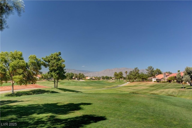 view of home's community with a mountain view and a lawn