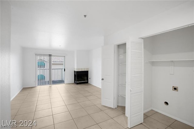 unfurnished living room with a fireplace and light tile patterned floors