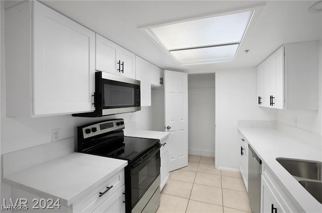 kitchen featuring sink, white cabinetry, stainless steel appliances, and light tile patterned floors