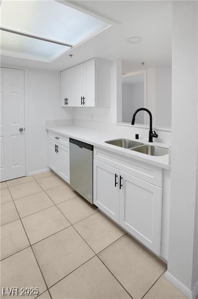 kitchen with white cabinetry, sink, light tile patterned floors, and stainless steel dishwasher