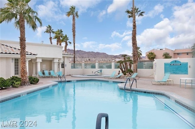 view of swimming pool with a mountain view and a patio