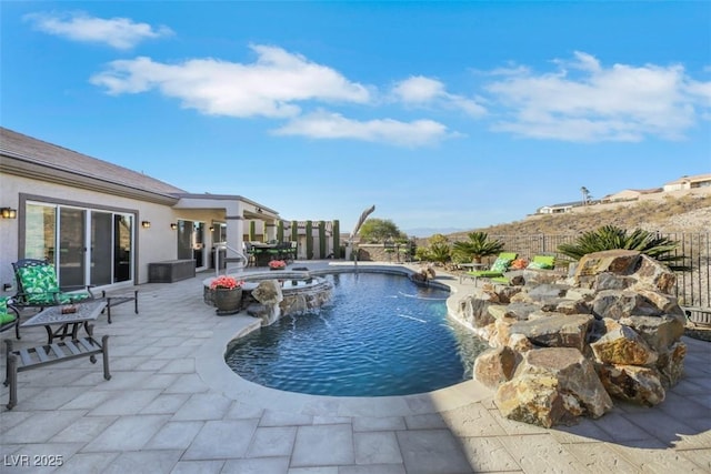 view of pool featuring pool water feature, an in ground hot tub, and a patio