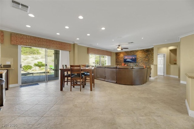 dining area with crown molding and ceiling fan