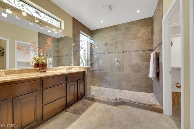 bathroom featuring vanity and tiled shower