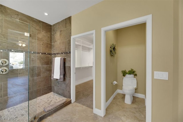 bathroom with tiled shower, tile patterned flooring, and toilet