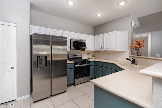 kitchen featuring stainless steel appliances, light tile patterned floors, tasteful backsplash, kitchen peninsula, and white cabinets