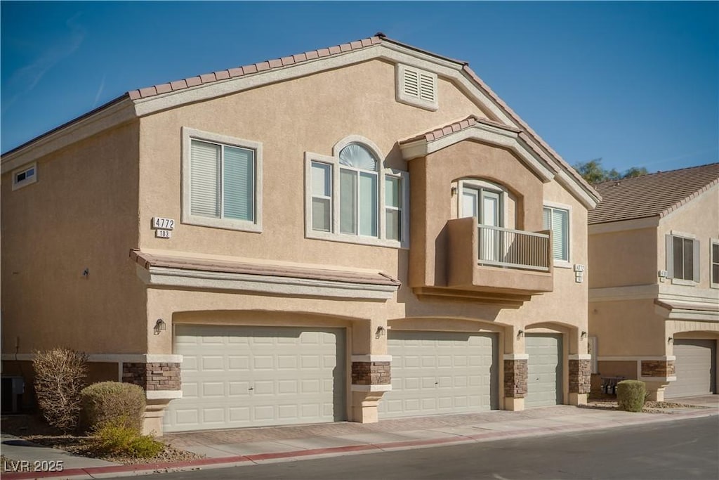 view of front of home featuring a garage and a balcony