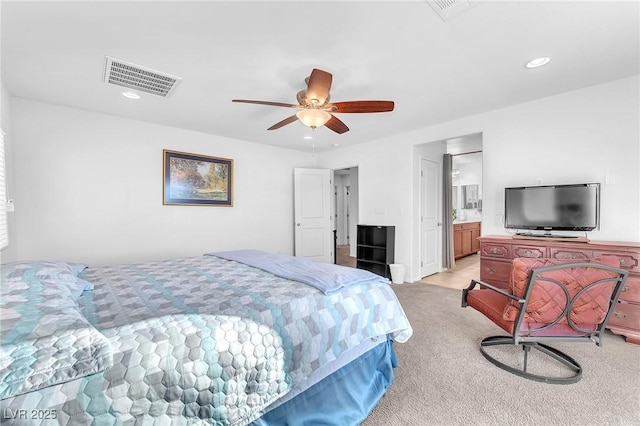 bedroom with connected bathroom, ceiling fan, and light colored carpet